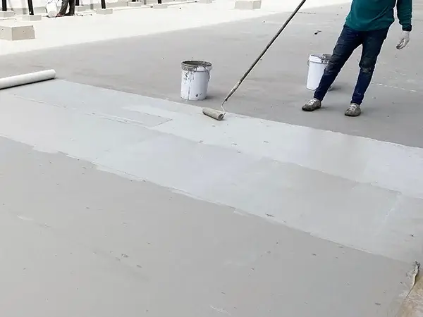 Roofer applying waterproofing solution on roof