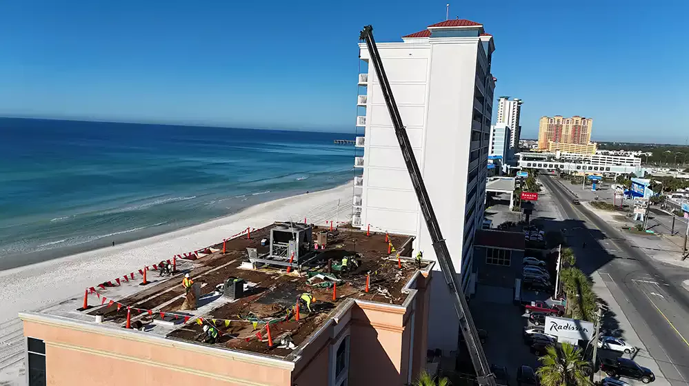 Workers tearing off old commercial roof by the beach